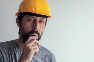Parlak arka plan üzerinde izole ciddi düşünceli inşaat mühendisi portresi