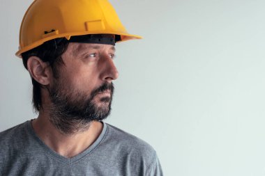 Parlak arka plan üzerinde izole ciddi düşünceli inşaat mühendisi portresi