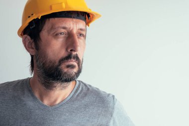 Parlak arka plan üzerinde izole ciddi düşünceli inşaat mühendisi portresi