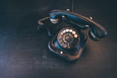 Siyah vintage sabit hat telefon, eski ve yıpranmış. Kırık iletişim kavramı.