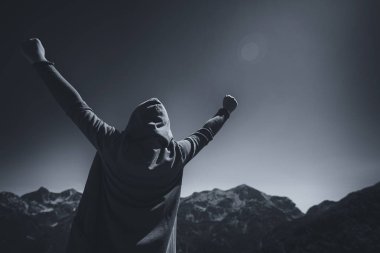 Mutlu ve memnun kadın yolcunun dağ başında duran ve ufka bakarak muzaffer V poz kaldırdı elleriyle