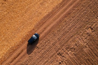 Kırsal toprak yolda havadan görünümü siyah arabanın üst görüntülemek dron pov sürüş araçtan