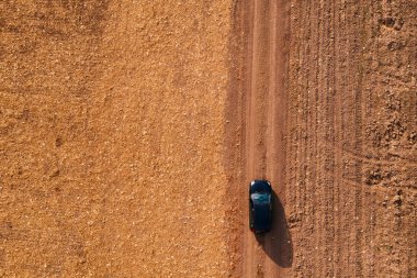 Kırsal toprak yolda havadan görünümü siyah arabanın üst görüntülemek dron pov sürüş araçtan