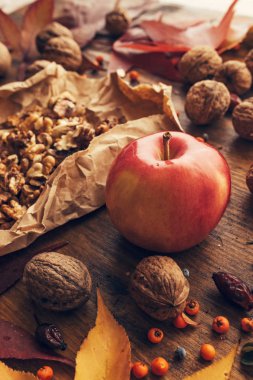 Elma ve ceviz, sonbahar bereket - sağlıklı organik meyve renkli akçaağaç yaprakları ve meyveleri, dekore edilmiş ahşap masa üzerinde Kapat