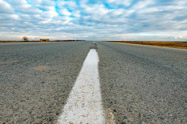 Soğuk kış günü kar olmadan kırsal aracılığıyla boş yol düşük açılı görünüş