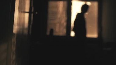 Karanlık bir odada ayakta pencerenin perişan depresif adam