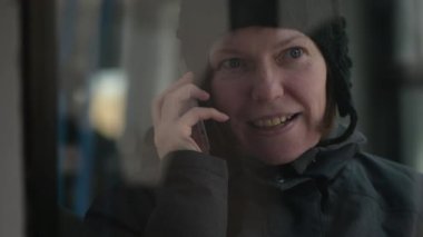 Güzel yetişkin kadın üstünde hareket eden telefon içinde halk otobüsü soğuk kış öğleden sonra söz.