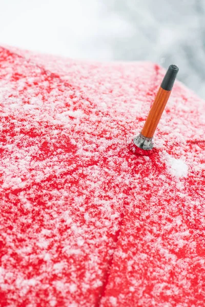 在有霜和雪花的雪中关闭红色的伞 — 图库照片