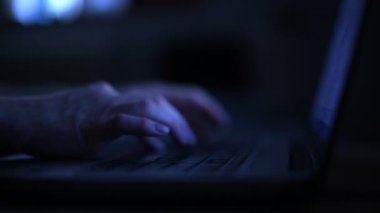Tipik dizüstü bilgisayar kapalı gece, seçici odak ile düşük anahtar eller