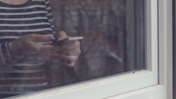 Mujer Usando Teléfono Móvil Para Mensajería Texto Por Ventana — Vídeos de Stock