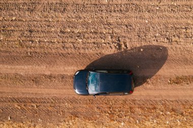 Kırsal toprak yolda havadan görünümü siyah arabanın üst görüntülemek dron pov sürüş araçtan