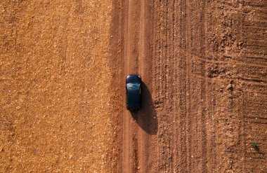 Kırsal toprak yolda havadan görünümü siyah arabanın üst görüntülemek dron pov sürüş araçtan