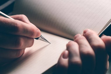 Defter, doğal ışık ile seçici odak yazma kadının el yakın çekim