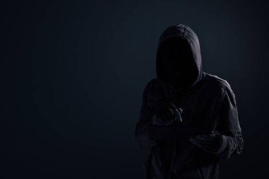 Bilgisayar korsanı gizlenmiş yüz siber suçlar ve cybersecurity kavram, düşük anahtar seçici odak ile dijital tablet kullanma başlıklı