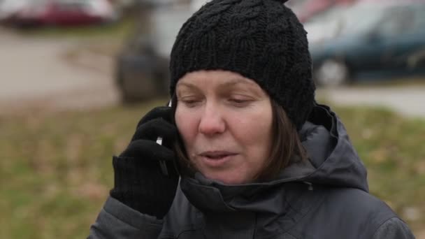 冬の寒い日に屋外携帯電話で話している深刻な女性 — ストック動画