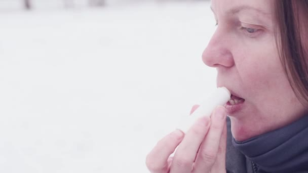 Vrouw Toepassen Lippenbalsem Uit Straat Een Koude Winterdag — Stockvideo