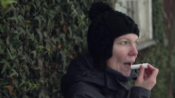 Γυναίκα Εφαρμογή Βάλσαμο Χειλιών Έξω Στο Δρόμο Για Μια Κρύα — Αρχείο Βίντεο