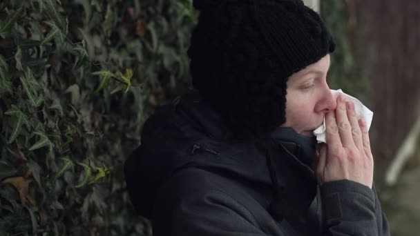彼女を吹く女性鼻紙ハンカチにアウト通りに冬の寒い日にインフルエンザのシーズンの開始時に — ストック動画