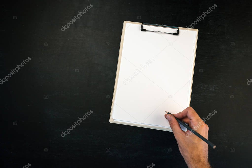 Writing on clipboard, male hand with pencil and blank page as copy space