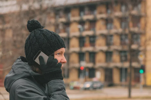 Mobile phone conversation on street in winter, adult caucasian woman talking on telephone