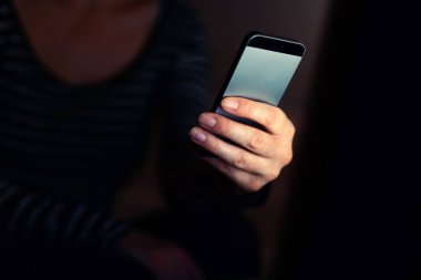 Kısa karanlık oda iç mesaj sms tipik elinde kapatmak için cep telefonu kullanan kadın