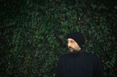 Askeri ceket açık havada ortak Ivy duvara kış öğleden sonra duran. serin yakışıklı adam portresi