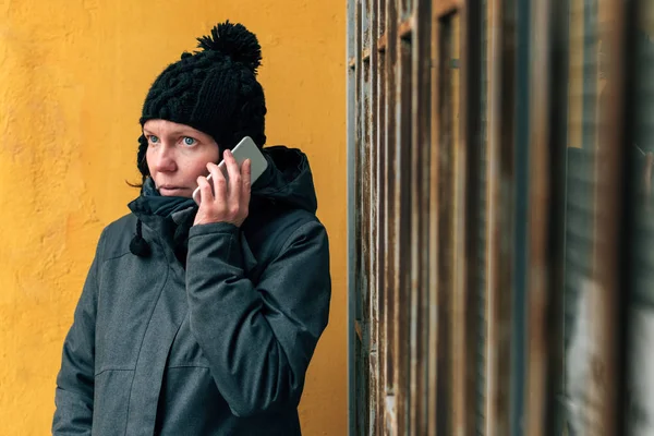 冬の路上で携帯電話での会話中に憤慨している女性の肖像画を呼び出す — ストック写真