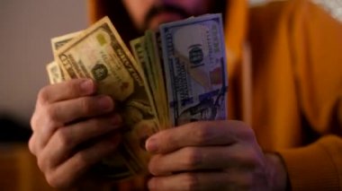 Casual adam Amerikan Doları banknot sayma, ellerin para ile yakın çekim