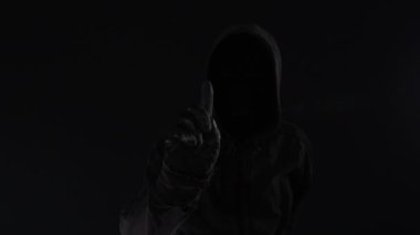 Meçhul kukuletalı erkek kişi, düşük anahtar görüntüleri dijital aksaklık etkisi ile ransomware konseptiyle