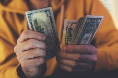 Casual adam Amerikan Doları banknot sayma, ellerin para ile yakın çekim
