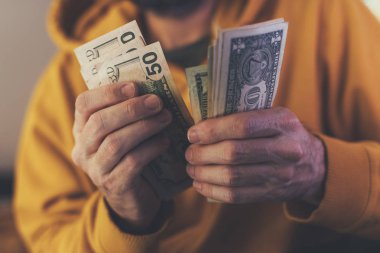 Casual adam Amerikan Doları banknot sayma, ellerin para ile yakın çekim