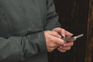 Kadın kışın sokağa smartphone kullanarak, rahat yetişkin kadın yazarak modern cep telefonu cihaz, seçici odak üzerinde iletisidir