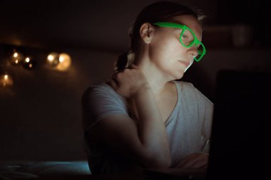 Dizüstü bilgisayarda gece geç saatlerde eve iş yerinde çalışırken şiddetli boyun ağrısı acı kadın