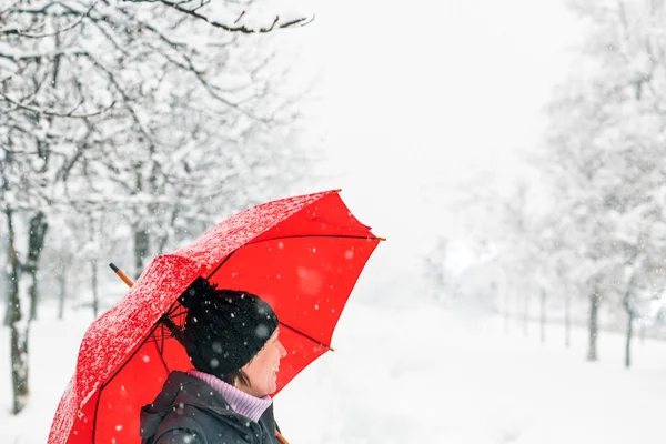 愉快的妇女与红色伞享受冬天雪在公园户外 — 图库照片