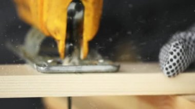 Elektrikli testere ile kesme ahşap tahta bir marangoz, ağır çekimde elektrikli el testeresi ve toz parçacıkları yakın çekim