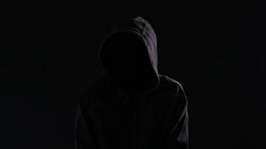 Ürkütücü ve tehdit holigan hoodie ve gizlenmiş yüz geceleri, şehrin sokaklarında yürüyüş ile