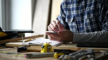 Marangoz küçük işletme ahşap atölyesinde smartphone app kullanarak proje hesaplama yapma