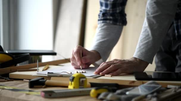 Carpinteiro Esboçando Projeto Madeira Papel Prancheta Sua Oficina Pequenas Empresas — Vídeo de Stock