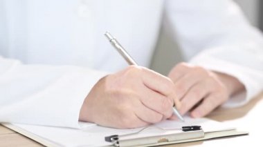 Doktor notlar yazıyor, kadın ellerini kapat.