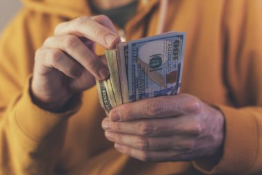 Casual adam Amerikan Doları banknot sayma, ellerin para ile yakın çekim