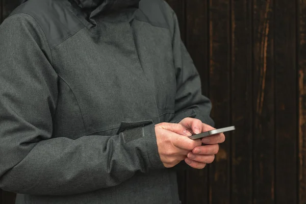 カジュアルな女性は 寒い冬の午後の通りに携帯電話のテキスト メッセージ 手のクローズ アップ — ストック写真