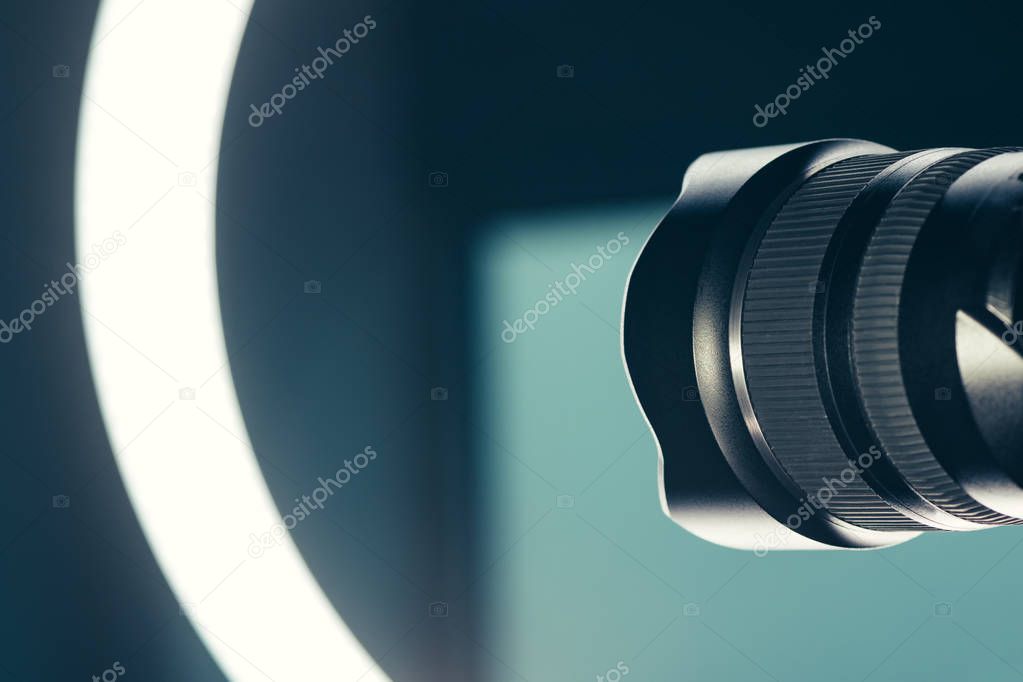 Camera lens and LED ring light in studio, photo and video production conceptual copy space