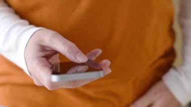 Kadın marangoz metin ileti, sms smartphone dokunmatik ekranda, seçici odak tipik el yakın için cep telefonu kullanıyor