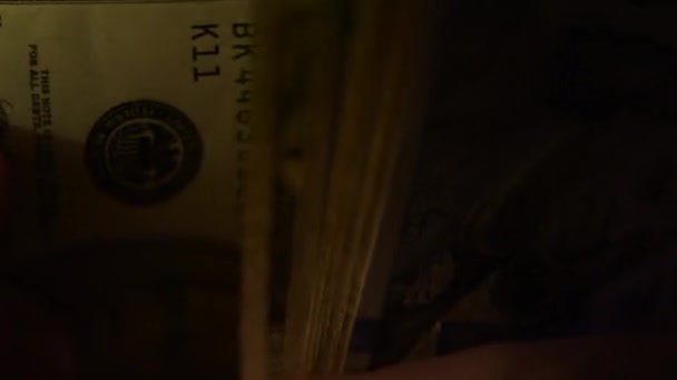 Detailní záběr z mužských rukou počítání peněz, nás dolarové bankovky v temné místnosti
