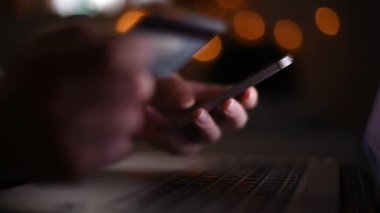 Karanlık odada, düşük anahtar görüntüleri seçici odak ile akıllı telefon app kullanarak online kredi kartı satın alma