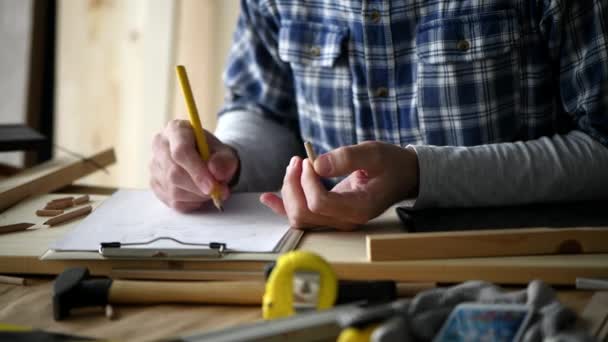 Carpinteiro Escrevendo Notas Projeto Examinando Cavilha Madeira Parafuso Oficina Madeira — Vídeo de Stock