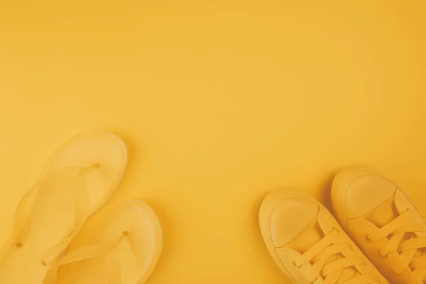 夏季鞋 黄色运动鞋和翻转拖鞋在相同的颜色背景与复制空间 — 图库照片