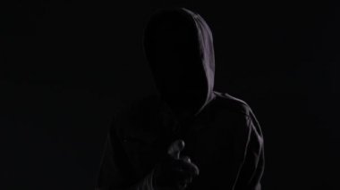Tanınmayan kukuletalı manyak stalker parmak dilinde veya sus işareti onun suç Yasası kurbanı susturmaya el hareketi