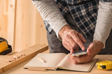 Marangoz küçük işletme ahşap atölyesinde smartphone app kullanarak proje hesaplama yapma