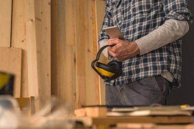 Yeni bir DIY proje planlama için küçük iş ahşap atölyesinde Smartphone kullanarak marangoz